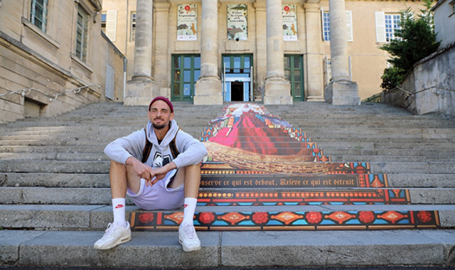 Piko Paseos, artiste poitevin, devant sa création Pop-Aliénor qui met à l'honneur les escaliers du Palais