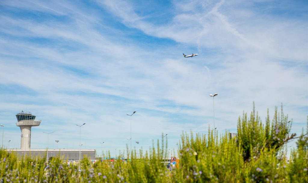 Tour de contrôle et avion en vol à l'aéroport de Bordeaux-Mérignac