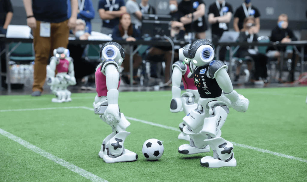 Trois robots humanoïdes en train de jouer au football