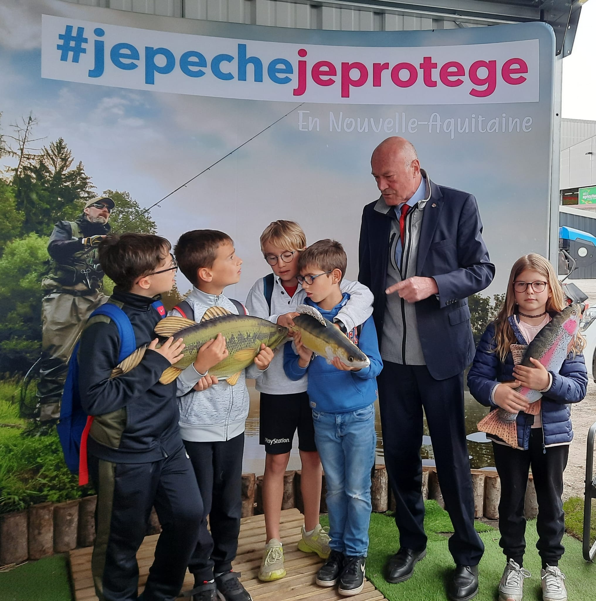 Alain Rousset, président de la région, à droite, discute avec les enfants au stand de la pêche