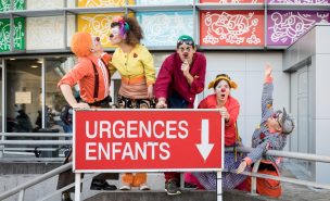 Cinq clowns posent devant la pancarte des urgences pour enfants