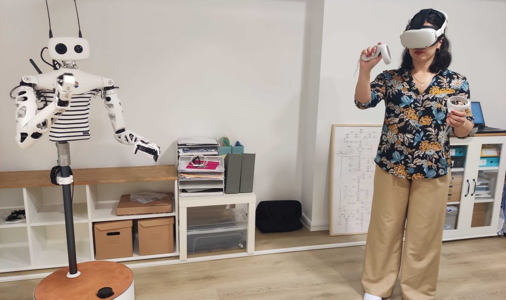 Un robot humanoïde, Reachly, piloté à distance par une personne équipée d'un casque de réalité virtuelle.