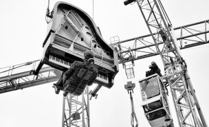 Un piano et son pianiste, Alain Roche, à la verticale, suspendus dans le vide par une grue