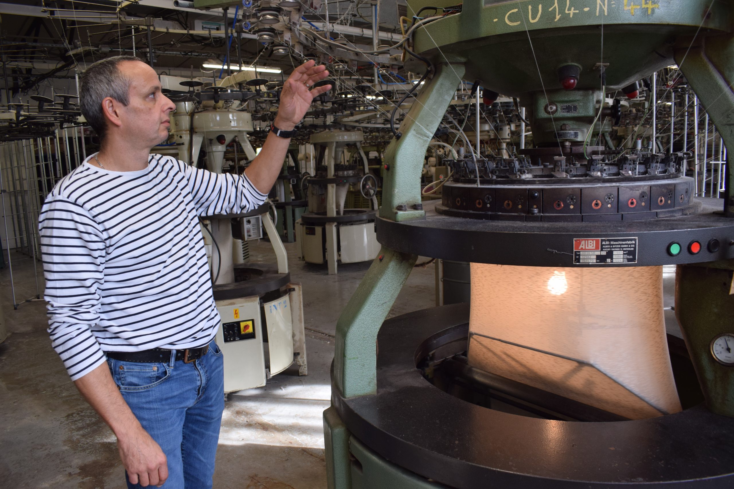 Alvéric Gélisse est le bonnetier de l'entreprise depuis 23 ans. Il a participé à l'aventure du déménagement en 2017, démontant puis remontant les machines à tricoter circulaires qu'il utilise tous les jours. Les 48 machines obéissent à un fonctionnement mécanique minutieux.