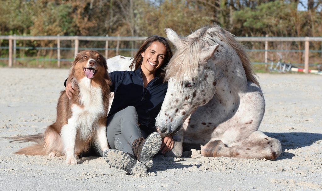 Agathe Sennesal, entre un chien et son cheval blanc Tangka.