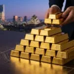 Mains plaçant des lingots d'or sur une pile devant un panorama urbain d'Osaka au crépuscule, évoquant un investissement majeur.