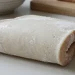 Gros plan sur deux tranches de pain de mie givrées sur une surface claire. Des cristaux de glace et de l'humidité sont visibles.