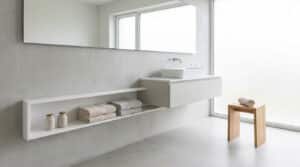 Salle de bain moderne avec meuble vasque suspendu, étagère encastrée et tabouret en bois clair.