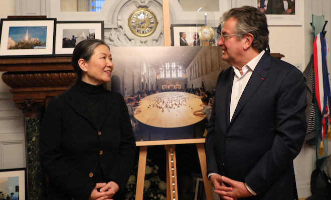 Alain Claeys et Kimsooja pose devant un cliché de l'oeuvre Archive of mind en évidence dans le bureau du maire de Poitiers